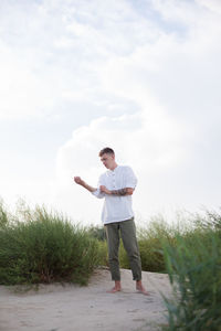 Full length of man standing on field against sky