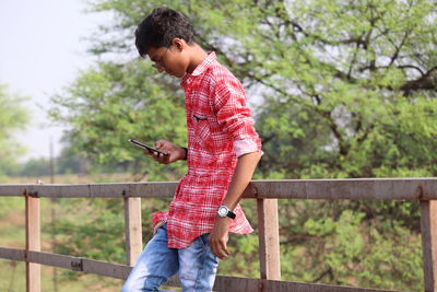 Full length of boy standing on railing