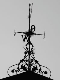 Low angle view of weather vane against clear sky