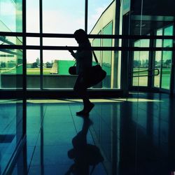 Silhouette of woman standing by railing