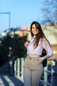 Portrait of smiling woman standing in city