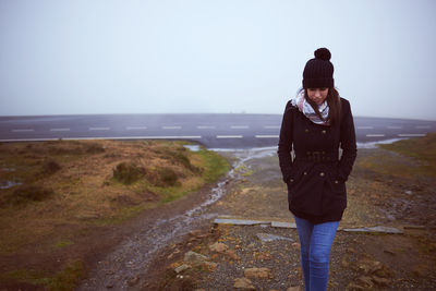 Woman walking on land against sky