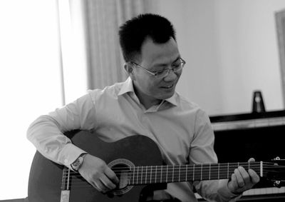 Man playing guitar at home