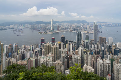 Aerial view of city buildings against cloudy sky