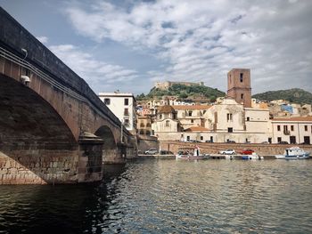 Bridge over river against buildings in city