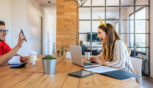 Laughing businesswoman and businessman talking at office