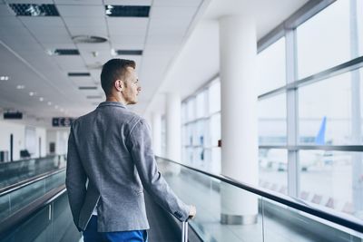 Rear view of man walking in airport building