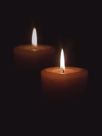 Close-up of lit candles against black background