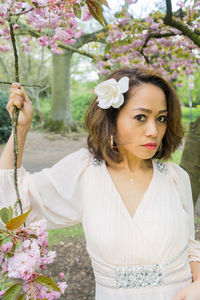 Portrait of young woman with flowers on tree