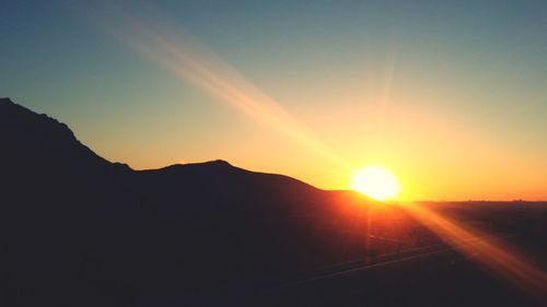 Scenic view of silhouette mountains against sky during sunset