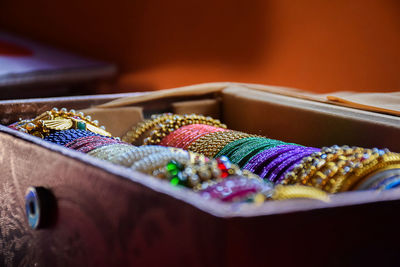 Close-up of multi colored bangles in container on table