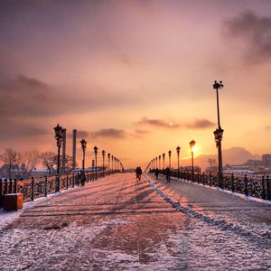 Snowy patriarchal bridge against sky during sunset