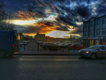 Cars on road against sky at sunset