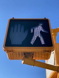 Low angle view of pedestrian crossing road sign against clear blue sky in mount vernon new york 