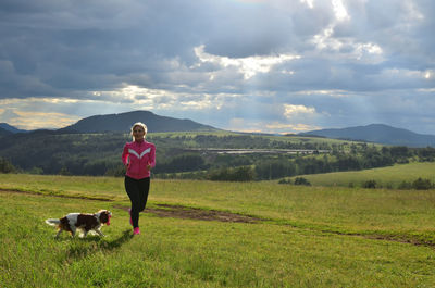 Lady running on a mountain meadow with her