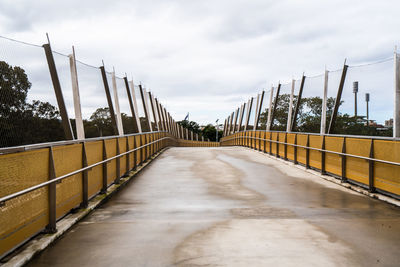 Empty footbridge against sky