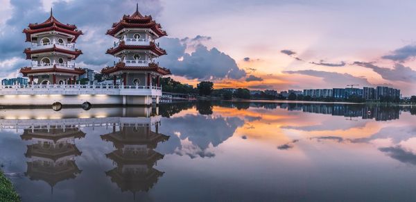 Reflection of buildings in lake at sunset