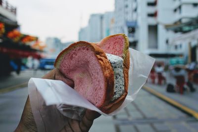 Close-up of hand holding ice cream cone on street