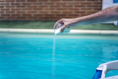 Man holding umbrella at swimming pool