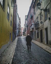 Rear view of man walking on street in city