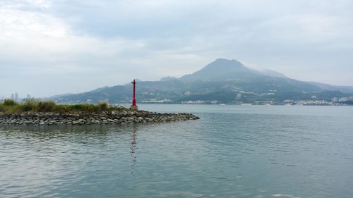 Calm lake with mountain range against the sky