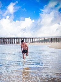 Man surfing in sea against sky