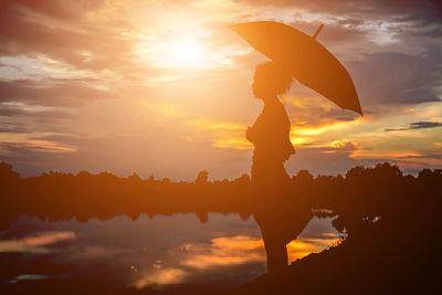 Silhouette person standing against sky during sunset