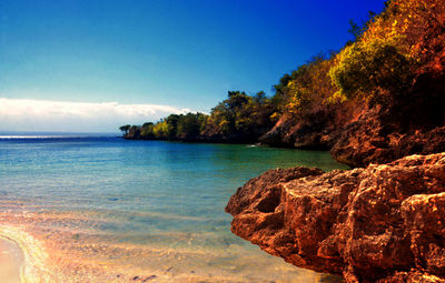 View of calm blue sea along rocky feature