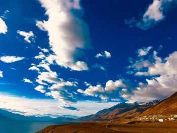 Scenic view of landscape and mountains against blue sky