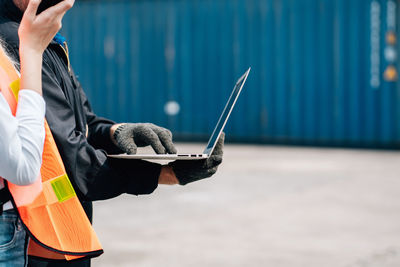 Midsection of man using mobile phone