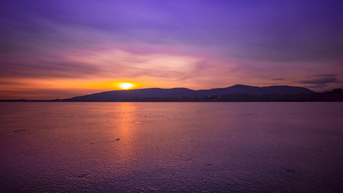 Scenic view of sea against romantic sky at sunset