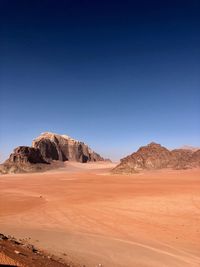 Scenic view of desert against clear blue sky