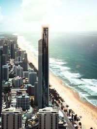 High angle view of buildings by sea against sky