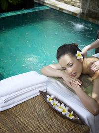 Cropped hands of woman massaging customer at poolside