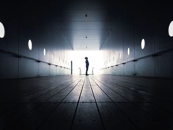 Full length of silhouette boy standing in corridor