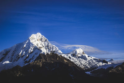 Scenic view of snowcapped mountains against blue sky