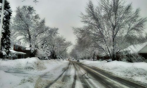 Snow covered road passing through landscape