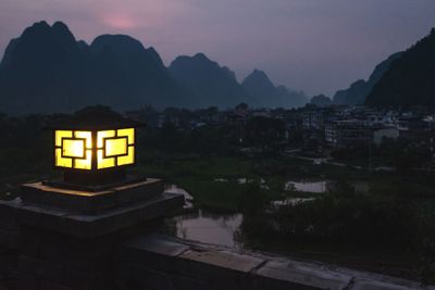 Illuminated building against sky at dusk