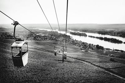 Overhead cable car on landscape against clear sky