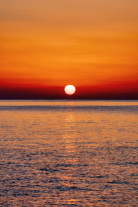 Scenic view of sea against orange sky