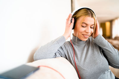 Young woman listening music on sofa at home