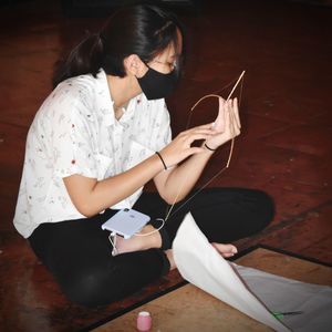 Midsection of woman using mobile phone while sitting on floor