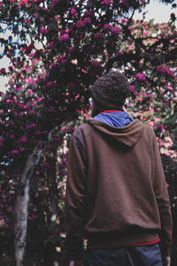 Rear view of woman standing against tree