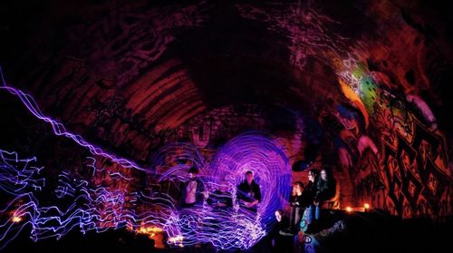 Low angle view of illuminated lighting equipment in cave