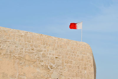 Low angle view of flag against clear blue sky