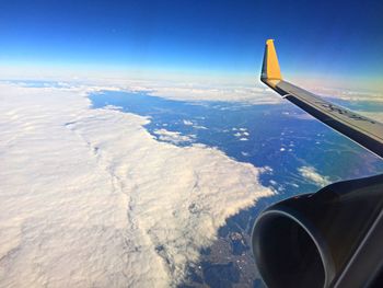 Airplane flying over landscape against sky