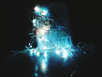 Close-up of illuminated lighting equipment against black background