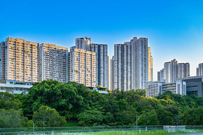 Buildings in city against clear blue sky