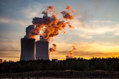 Panoramic view of factory against sky during sunset