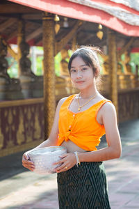 Portrait of young woman looking away while standing outdoors